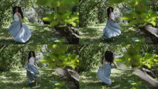 迷人的黑发女郎移动她的长连衣裙站在绿色的花园高清在线视频素材下载