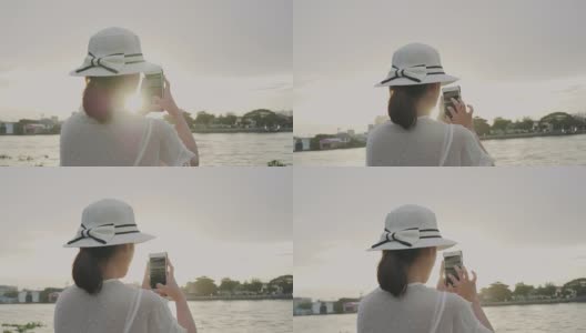 复古风格的泰国女性后视图是用智能手机拍照，在日落之前拍摄河流的景色高清在线视频素材下载