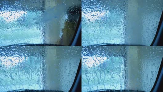 洗车房里的水和肥皂水冲下汽车的前部高清在线视频素材下载