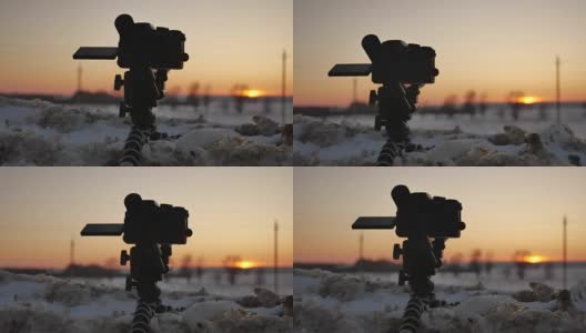 数码单反相机拍摄冬季风景。单反相机拍摄的日落与冬天的自然雪高清在线视频素材下载