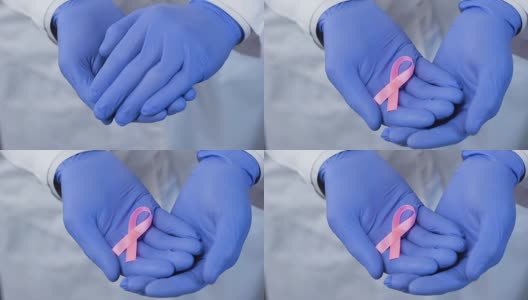 双手戴着手套小心翼翼地握着粉红丝带，象征对乳腺癌的关注高清在线视频素材下载
