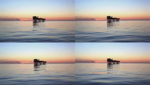 日落时海上石油平台的剪影高清在线视频素材下载