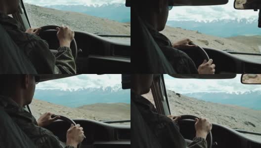 从SUV汽车内部的部分内饰和镜子与司机男性的手在方向盘上危险笔直的山路在阳光明媚的日子与雪山的背景高清在线视频素材下载