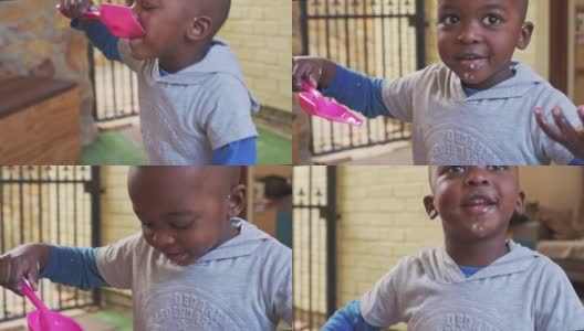 可爱的小男孩正用塑料铲吃着可食用的粘稠物高清在线视频素材下载