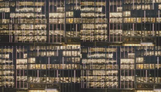 鸟瞰图的现代办公室在玻璃摩天楼在晚上，全景左边。高清在线视频素材下载