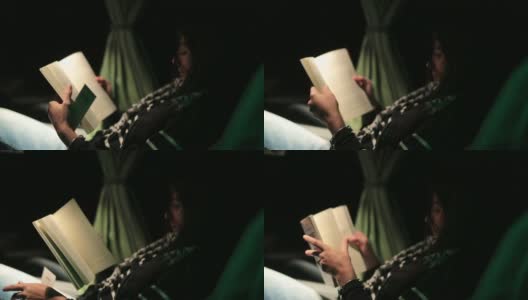 一个女人在一晚上旅行的公交车上看书高清在线视频素材下载