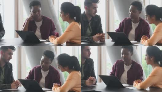 三个年轻的学生在大学里使用笔记本电脑并讨论高清在线视频素材下载