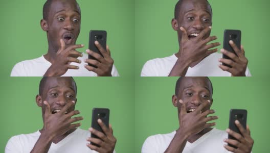 年轻快乐的非洲男子在使用电话时看起来很震惊高清在线视频素材下载