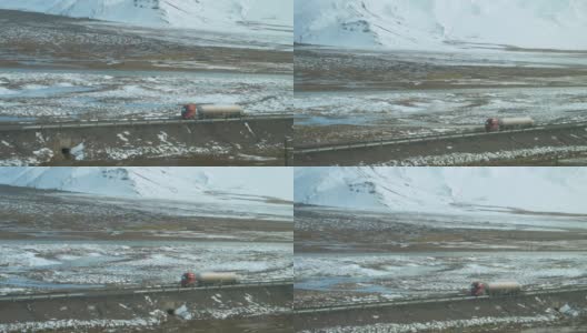 慢镜头:卡车沿着空旷的道路行驶，驶过喜马拉雅山脉。高清在线视频素材下载