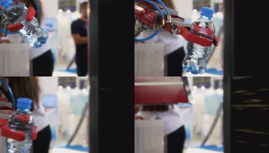 近景为红色机器人手拿一瓶水，背景模糊，人工智能概念。媒体。自动化工业机械设备高清在线视频素材下载
