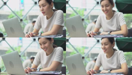 亚洲自由职业女性使用她的笔记本电脑和工作在咖啡店高清在线视频素材下载