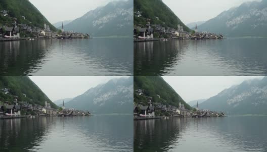 哈尔斯塔特-奥地利阿尔卑斯山脉之间的湖上的历史村庄。奥地利建筑，教堂和小教堂。灰色的多云的天空。山坡上的绿色森林。高清在线视频素材下载