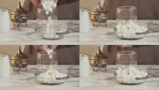 玻璃盘子上的棉花糖靠近大理石背景。女人准备热巧克力和棉花糖高清在线视频素材下载