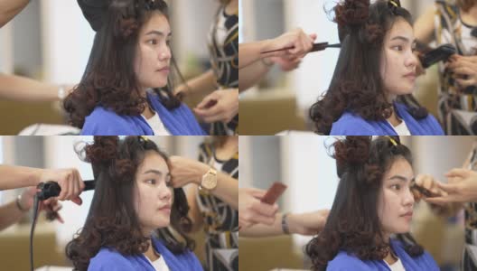 亚洲妇女在美容院，她卷头发和拉直头发。高清在线视频素材下载