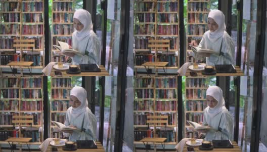 一个女人在图书馆的咖啡厅里看书高清在线视频素材下载