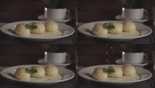 厨师将坚果洒在美味的传统乌克兰菜Gombovtsi奶酪饺子上高清在线视频素材下载
