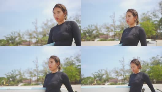 亚洲女人在莽撞的警卫手持冲浪板在海滩上行走高清在线视频素材下载