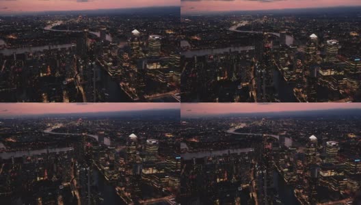城市夜间的空中全景画面。金丝雀码头商业中心的摩天大楼与第一加拿大广场的金字塔屋顶的主导照明。城市的黄昏。英国伦敦高清在线视频素材下载