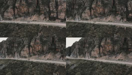 深灰色的汽车在山间的狭窄道路上行驶。无人机视频高清在线视频素材下载