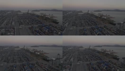 日落之后的海港码头上，卡车仍在密集的集装箱间忙碌穿梭高清在线视频素材下载