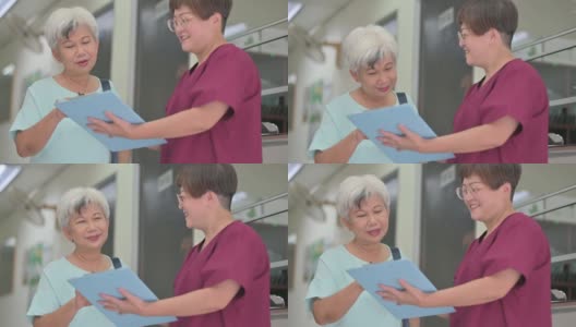 亚裔华裔女护士在诊所向她的资深女病人解释体检报告高清在线视频素材下载