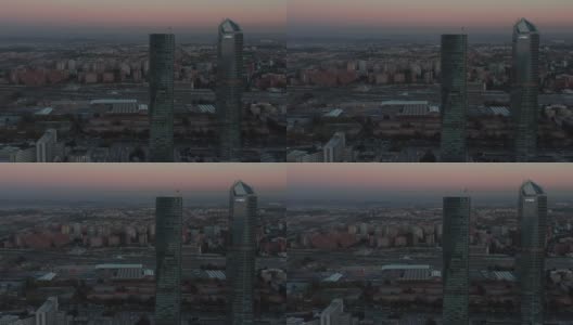 日落后高层办公大楼的鸟瞰图。背景是运输终端和开往车站的火车高清在线视频素材下载