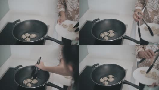 亚裔华人老太太周末在厨房教孙女煮饺子高清在线视频素材下载
