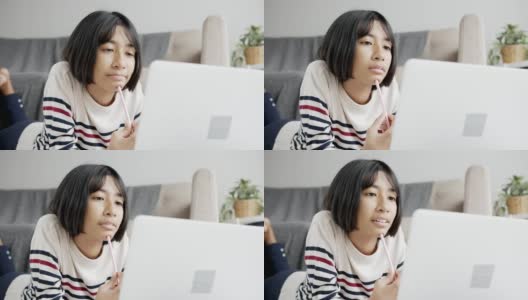 亚洲女孩在网上学习通过网络在笔记本电脑上和导师，躺在客厅的地板上。在家在线学习的概念高清在线视频素材下载