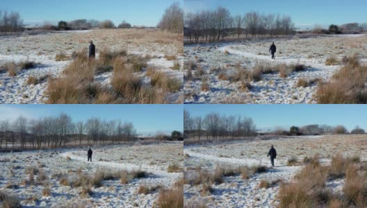 一名老年男子在苏格兰西南部一条被雪覆盖的人行道上行走的无人机画面高清在线视频素材下载