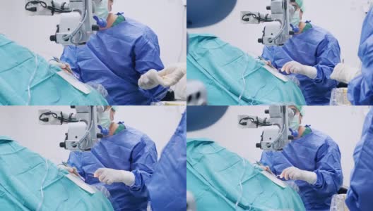 仪器护士为眼科医生增加手术工具和打字监视器触摸屏。眼科医生在他的诊所给病人做手术高清在线视频素材下载