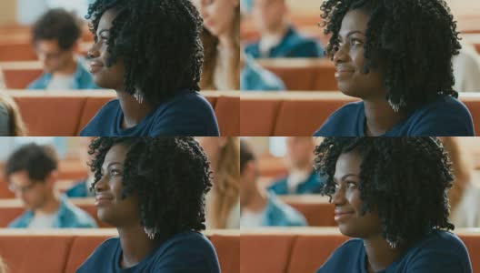 一个聪明美丽的年轻黑人女孩在一间满是多民族学生的教室里听讲座的肖像。年轻人在大学学习。高清在线视频素材下载