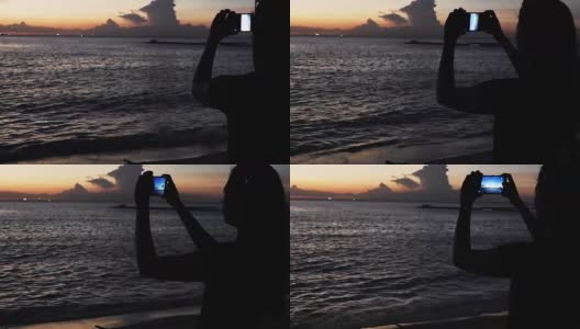在海边度假的海滩上，一个女人用她的智能手机拍照。高清在线视频素材下载