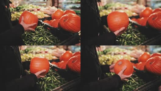 美丽的女孩正在超市里的蔬菜摊上挑选南瓜，作为秋季节日，比如万圣节高清在线视频素材下载