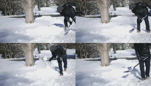 在寒冷的冬天，一名男子用铁锹铲他的车道高清在线视频素材下载