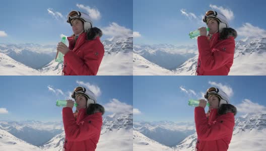 女子滑雪饮用干净的水从一个塑料瓶在一个山的背景高清在线视频素材下载
