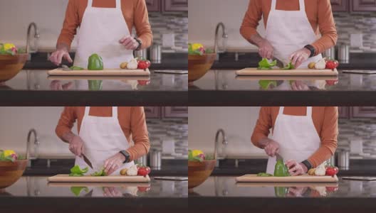 老厨师拿起刀，在砧板上切了一个甜椒。高清在线视频素材下载