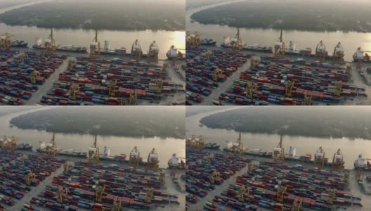 日落时分，无人机与起重机在国际港口上空飞行的鸟瞰图高清在线视频素材下载