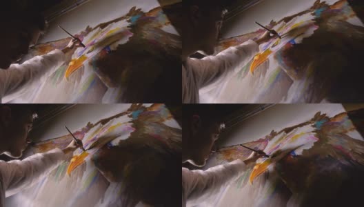 艺术家设计师在墙上画了一只鹰。工匠装饰用丙烯酸颜料画一幅画。画家穿着一件油漆外套。高清在线视频素材下载