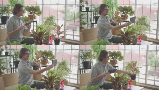 这是在新冠疫情期间快乐地在家园艺的一种爱好。一名男子正在用平板电脑给自家花园里的植物拍照高清在线视频素材下载