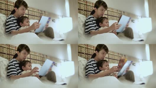 亚洲母亲和孩子，在睡觉前看书。高清在线视频素材下载
