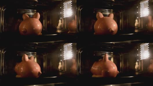 小猪储蓄罐在微波炉里烤着。支持资金，用于家电上的资金。高清在线视频素材下载