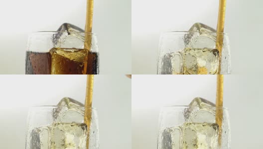 苏打水装在玻璃杯里，冰通过管子喝。白色背景。近距离高清在线视频素材下载