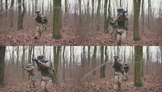 一群年轻的武装士兵在一个地区的武装冲突中穿着制服以突击步枪瞄准森林，慢镜头，软式高清在线视频素材下载