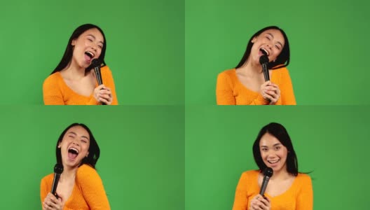 美丽开朗的亚洲女人快乐享受卡拉ok麦克风在一个孤立的绿色背景高清在线视频素材下载