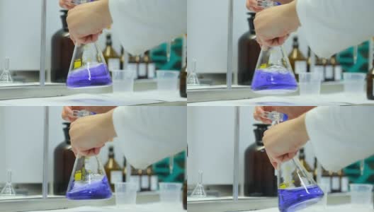 科学实验室中的化学实验室研究。化学家手里拿着一个玻璃烧瓶高清在线视频素材下载
