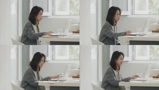 美丽的中国女商人视频会议使用笔记本电脑在家工作高清在线视频素材下载