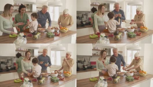 在他们的家庭早午餐期间，兴奋的蹒跚学步的孩子用一片黄瓜喂祖父母和他的阿姨高清在线视频素材下载