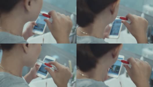 女人在浴室里刷牙和使用智能手机高清在线视频素材下载