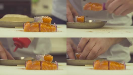厨师用手将酱汁和盐倒在鱼上高清在线视频素材下载