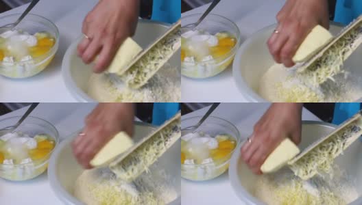 一位妇女在混合配料，准备做大理石蛋糕。用磨粉器把黄油磨成面团。高清在线视频素材下载
